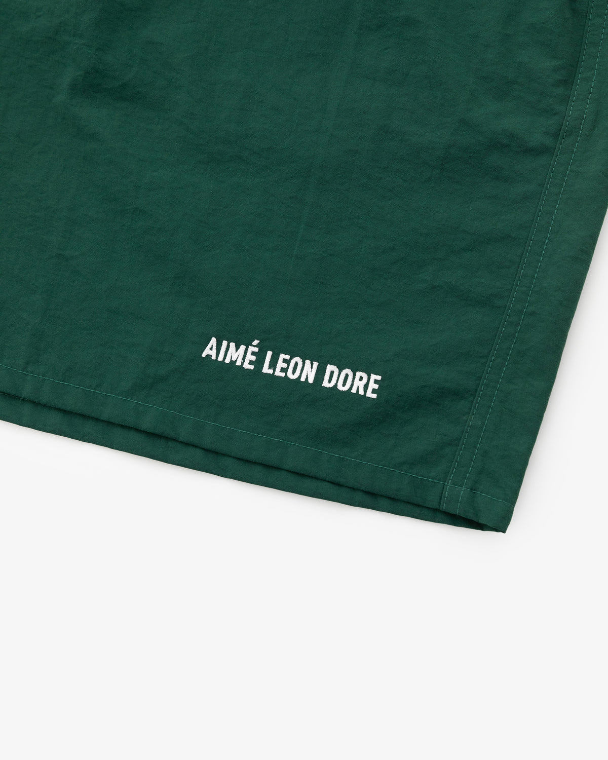 Green Logo Swim Short with white AIMÉ LEON DORE text near the hem.
