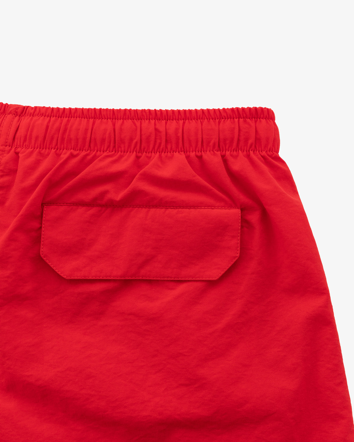 Close-up of the back pocket and waistband of Logo Swim Short in bright red against a plain white background.