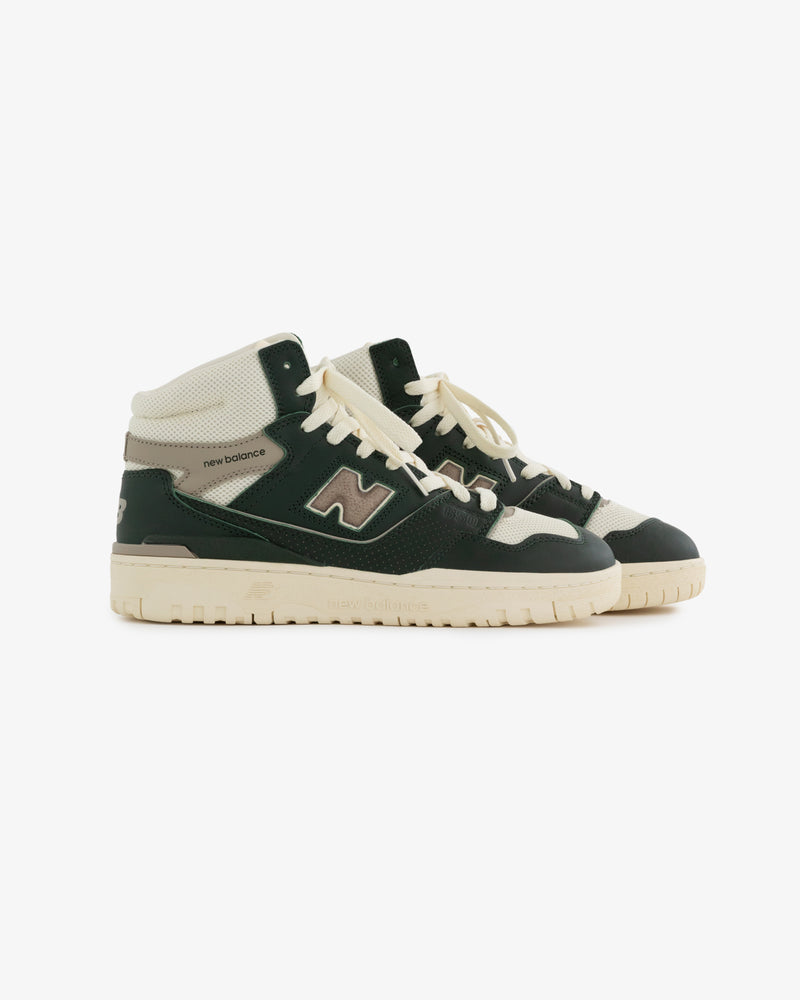 A pair of black, white, and cream ALD / New Balance 650R high-top sneakers with laces on a white background.