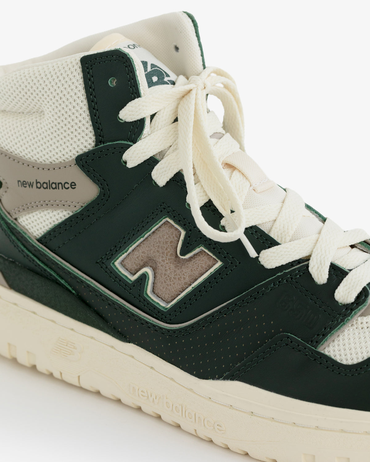 Close-up of the ALD / New Balance 650R sneaker in cream and green with mesh, leather, and a large "N" side logo.